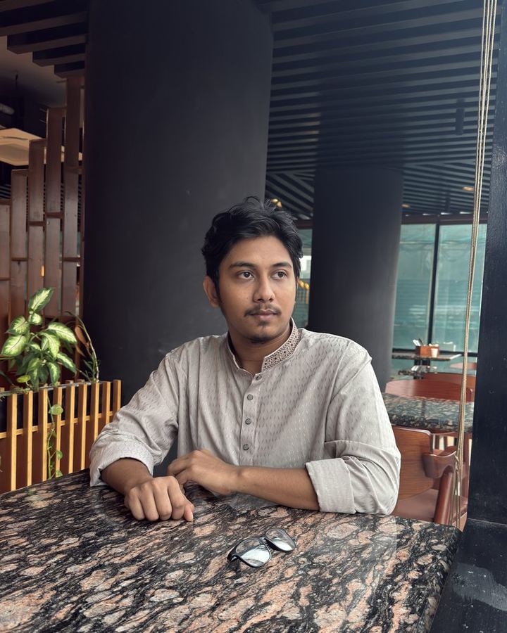 Shahparan Rimon sitting at a marble table by a window