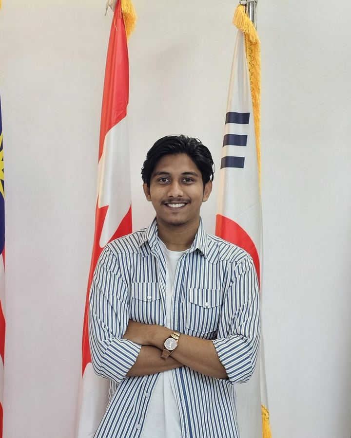 Shahparan Rimon standing in front of international flags